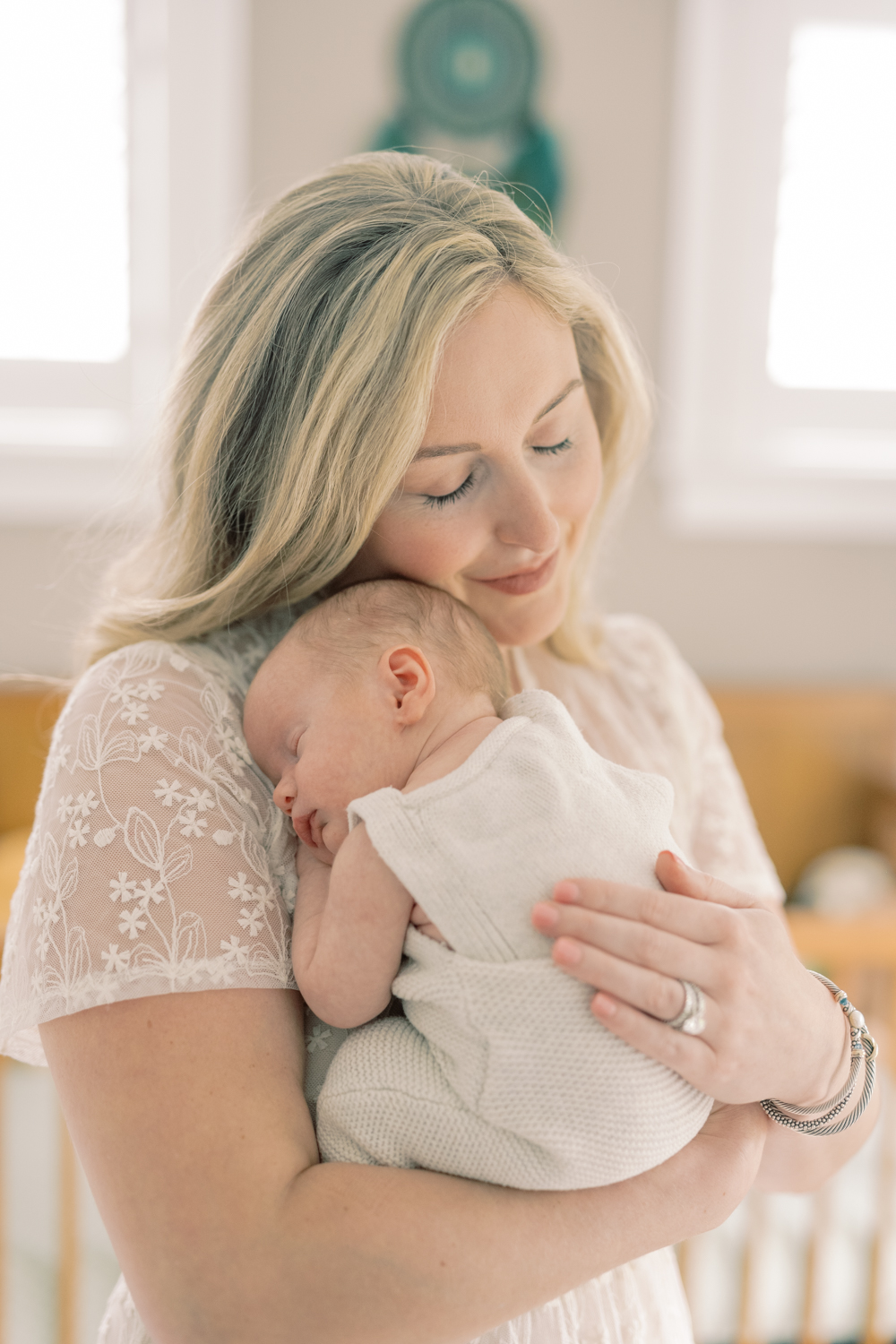new mama holding her newborn in nursery by amanda mcquade photography