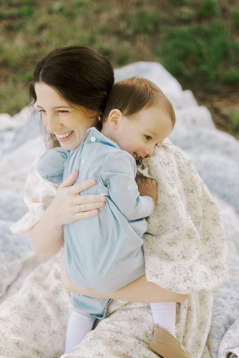 mother hugging little boy in heirloom clothing outside photographed by amanda mcquade