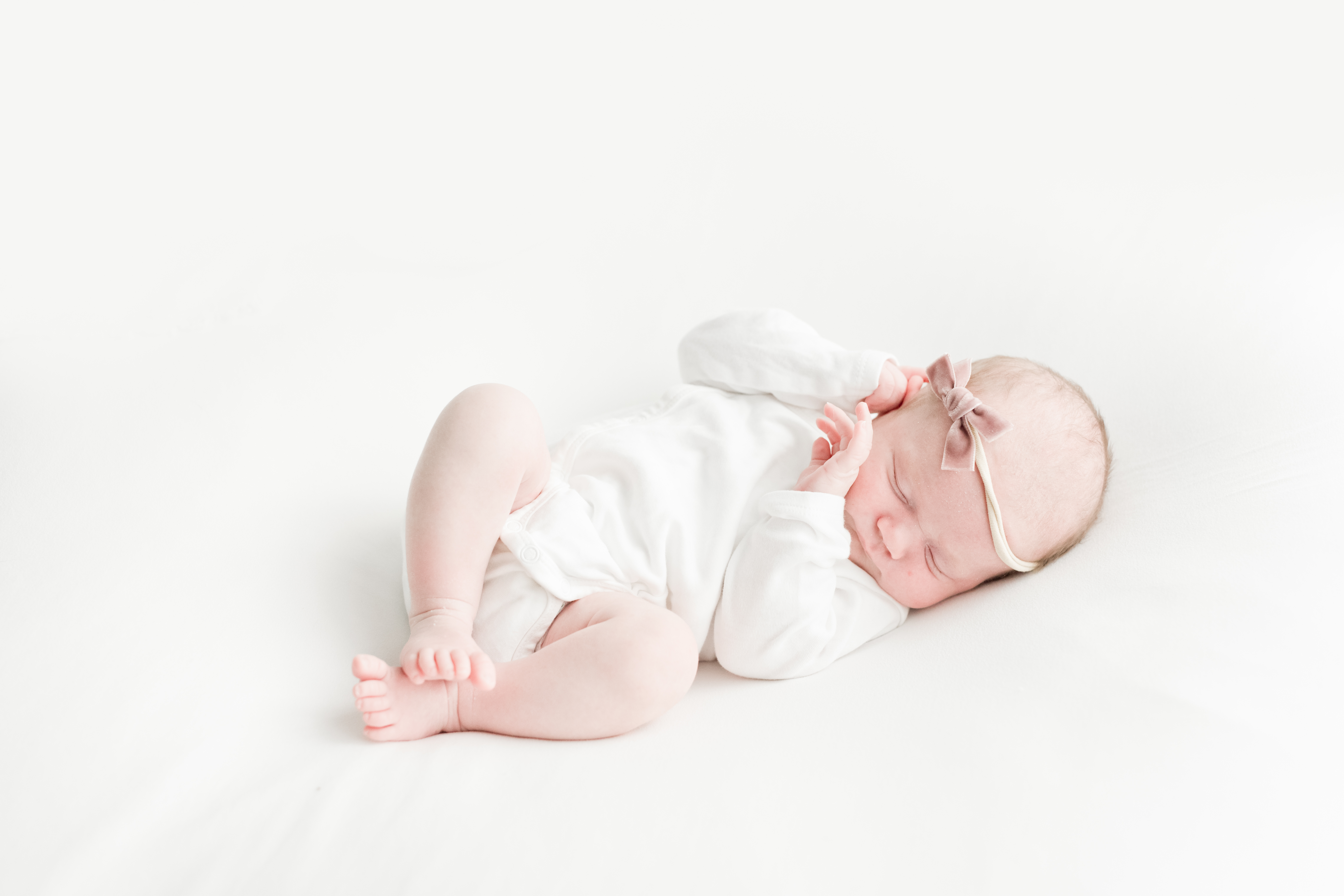 newborn baby girl photographed by a professional photographer with white backdrop in charlotte, NC